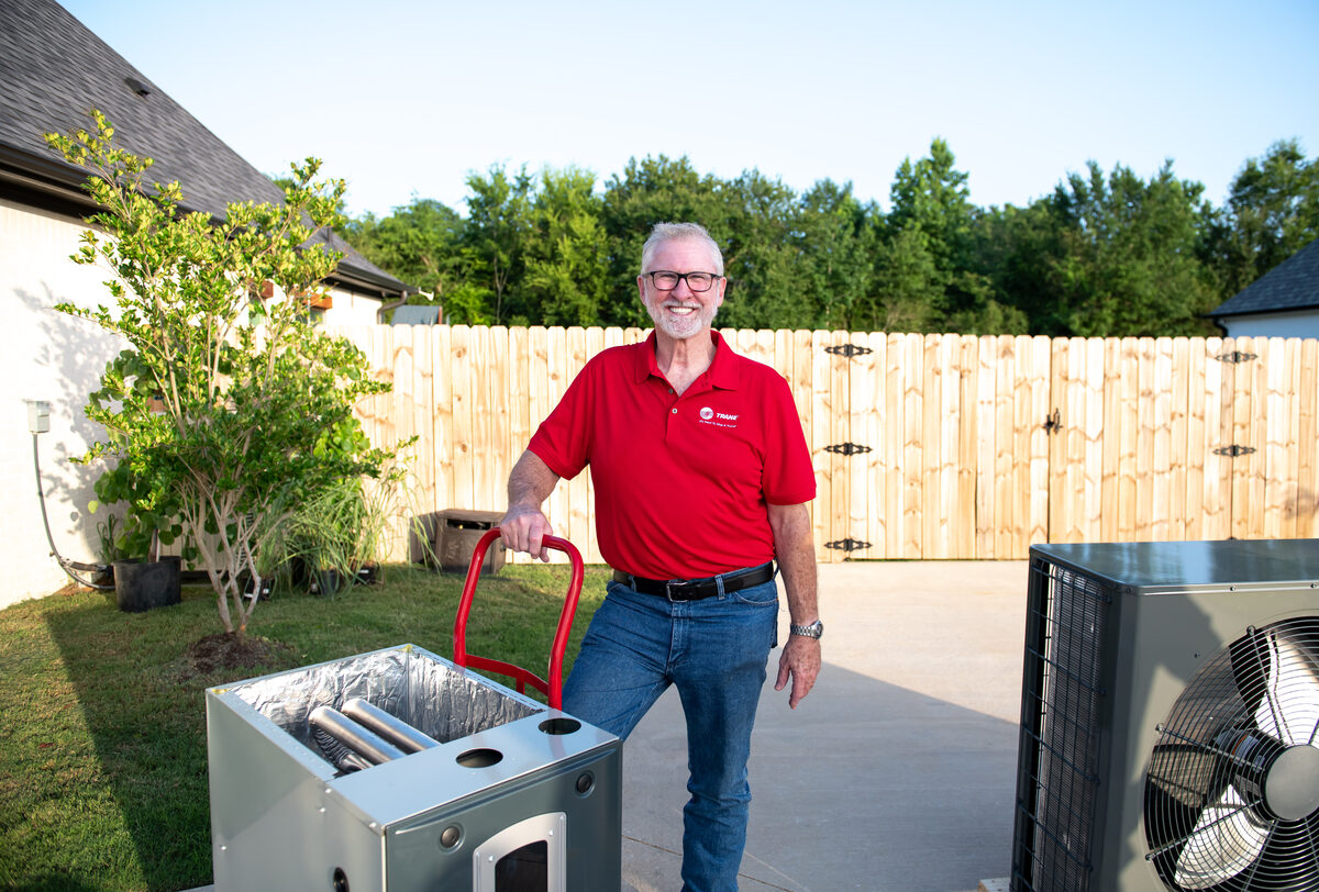 Homeowner and technician standing outdoors discussing service