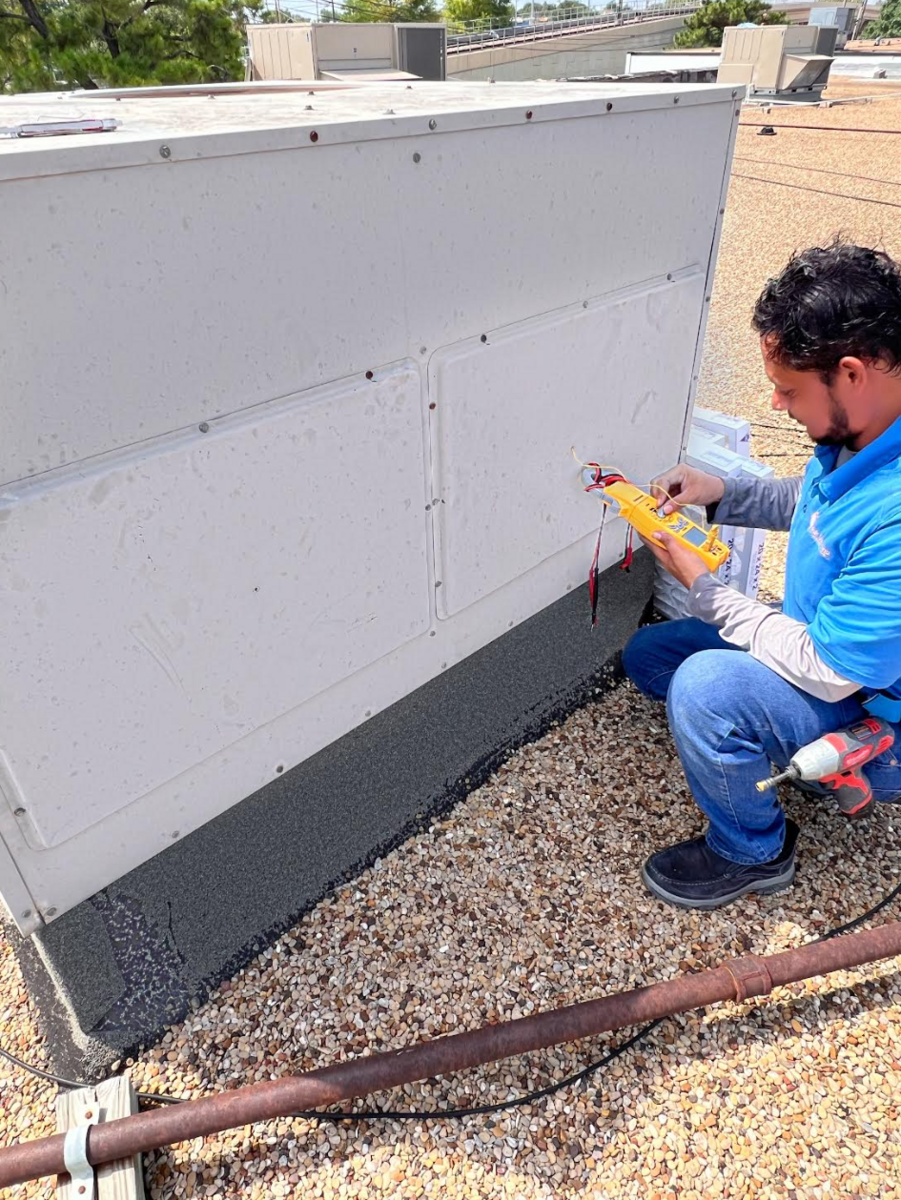 Technician inspecting or repairing an HVAC unit outdoors