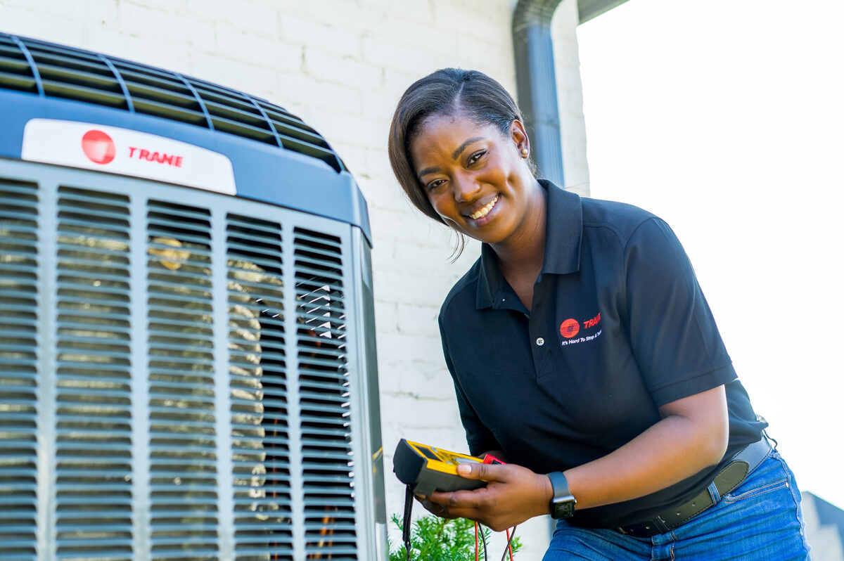 Technician servicing rooftop HVAC equipment