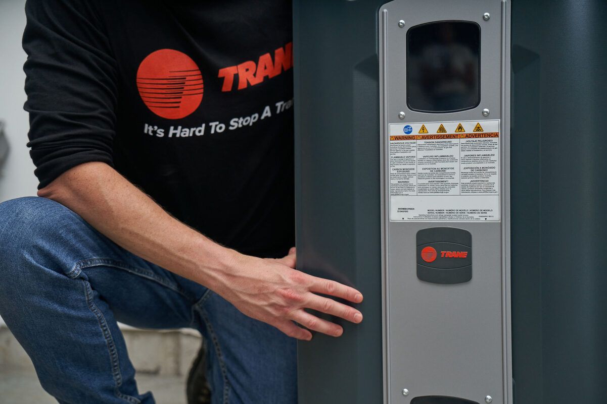 Technician working on an outdoor air conditioning unit